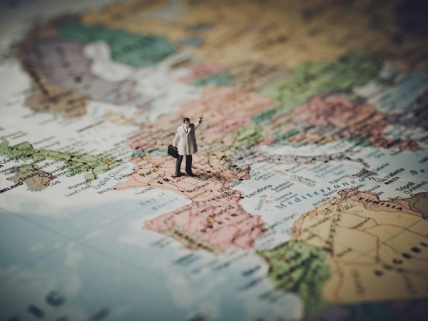 Miniature businessman on map of Europe. Color tone tuned
